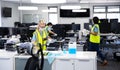 Team wearing hi vis vest and face mask cleaning the office using disinfectant Royalty Free Stock Photo