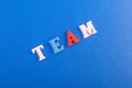 TEAM word on blue background composed from colorful abc alphabet block wooden letters, copy space for ad text. Learning english