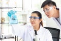 Team work asian woman and man Scientists analyzing study data and evaluating microscope success for work shop. Royalty Free Stock Photo