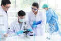 Team work asian woman and man Scientists analyzing study data and evaluating microscope success for work shop. Royalty Free Stock Photo