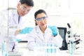 Team work asian woman and man Scientists analyzing study data and evaluating microscope success for work shop. Royalty Free Stock Photo