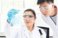 Team work asian woman and man Scientists analyzing study data and evaluating microscope Royalty Free Stock Photo