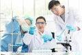 Team work asian woman and man Scientists analyzing virus data and evaluating microscope Royalty Free Stock Photo