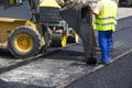 Workers construct asphalt road and railroad lines Royalty Free Stock Photo