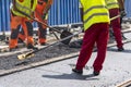 Workers construct asphalt road and railroad lines Royalty Free Stock Photo