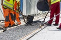 Workers construct asphalt road and railroad lines Royalty Free Stock Photo