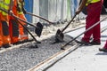 Workers construct asphalt road and railroad lines Royalty Free Stock Photo