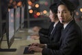 Team of workers wearing headphone headset and working with happy face in front of computer screen at call center in office with Royalty Free Stock Photo