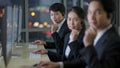 Team of workers wearing headphone headset and working with happy face in front of computer screen at call center in office with Royalty Free Stock Photo