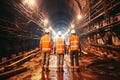 A Team of Workers wearing safety gear work underground together in the construction of a subway tunnel. Construction teamwork Royalty Free Stock Photo