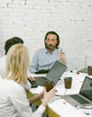 Team working on new business project. Office workers communicate sitting at desk with computers and paper cups of coffee