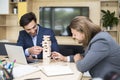 Team of young business people build a wooden construction in the