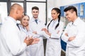 Team of young doctors in lab coats discussing work