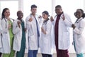 Team of young doctors, mixed race. People of different sex, in white coats, with phonendoscopes, posing, smiling Royalty Free Stock Photo