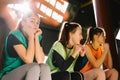 A team of young girls sitting on the bench in multi-colored vests are worried and worried about their team. The girls Royalty Free Stock Photo