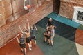 team of young guys playing basketball in the yard and throw the ball in the basket. Aerial view from