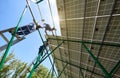 Team of young mounters working with solar panels screen.