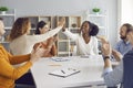 Happy business women making a deal and high fiving each other sitting at table in group meeting Royalty Free Stock Photo