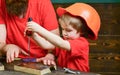 Teamwork and assistance concept. Boy, child busy in protective helmet learning to use screwdriver with dad. Father Royalty Free Stock Photo