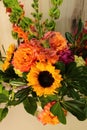 teamwork: blend of fall color flowers in flower arrangement: yellows, orange, peach, purple green