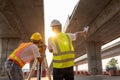 Teamwork of civil engineer and surveyor engineers making measuring under the expressway with theodolite on road works. Survey Royalty Free Stock Photo