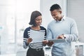 Teamwork clearly makes the dream work. two young businesspeople standing in their office and working together using a Royalty Free Stock Photo