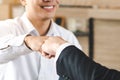 Teamwork colleagues in corporate concept. Two businessmen do fist bumping in the office celebrate successful new project start Royalty Free Stock Photo