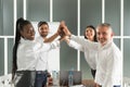 Teamwork concept. Happy successful multiracial business team giving a high fives gesture as they laugh and cheer their