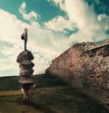 Teamwork concept. Man with a stack of stones on his back and a man stading on top of them, Royalty Free Stock Photo