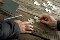 Teamwork and cooperation between two business people as they join forces to combine matching puzzle pieces