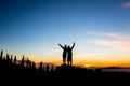 Teamwork couple climbing and reaching mountain peak