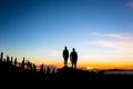 Teamwork couple climbing and reaching mountain peak