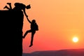 Teamwork couple hiking help each other trust assistance silhouette in mountains, sunset. Teamwork of man and woman hiker helping e Royalty Free Stock Photo