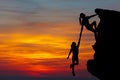 Teamwork couple hiking help each other trust assistance silhouette in mountains, sunset. Teamwork of man and woman hiker helping e Royalty Free Stock Photo