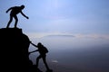 Teamwork couple hiking help each other trust assistance silhouette in mountains, sunset. Teamwork of man and woman hiker helping e Royalty Free Stock Photo