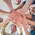 Teamwork divides the task and multiplies the success. Low angle shot of a group of co-workers stacking their hands on