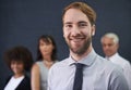 Teamwork divides the task and multiplies success. a young professional man standing in front of a group of coworkers. Royalty Free Stock Photo