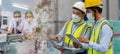 Teamwork engineer in uniform wear protection mask brainstorming with worker inspector checking quality. Royalty Free Stock Photo