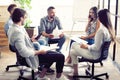 Teamwork is a key to success. Business people in smart casual wear talking and smiling while having a brainstorm meeting Royalty Free Stock Photo