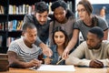 Teamwork makes the assignment work. a group of young students working on an assignment together in a college library. Royalty Free Stock Photo