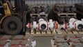 Man on forklift transporting Oil and Gas Wellhead tree equipment production plant on pallets in warehouse. Modern