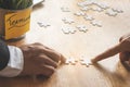 Teamwork, partners, connection concept. Hands of two businessmen merging jigsaw puzzle on the working table