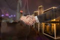 Teamwork, partnership and success concept. Double exposure of business handshake for successful of investment deal and city night Royalty Free Stock Photo