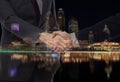 Teamwork, partnership and success concept. Double exposure of business handshake for successful of investment deal and city night Royalty Free Stock Photo