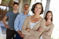 Teamwork, portrait and senior female manager in office, leader and CEO in workplace with team. Face, smile and Royalty Free Stock Photo