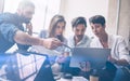 Teamwork process.Young coworkers work with new startup project in office.Woman holding touch pad in hands,bearded man