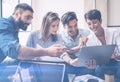 Teamwork process.Young entrepreneur work with new startup project in office.Woman holding touch pad in hands,bearded man Royalty Free Stock Photo