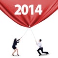 Teamwork pulling the banner of new year of 2014 Royalty Free Stock Photo