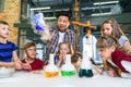 Teamwork of school children and their teacher with chemical experiment at modern well equiped laboratory. Royalty Free Stock Photo