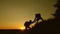 Teamwork silhouette of group of hikers lends a helping hand in climbing mountains, hill. Uristy climb mountain at sunset Royalty Free Stock Photo